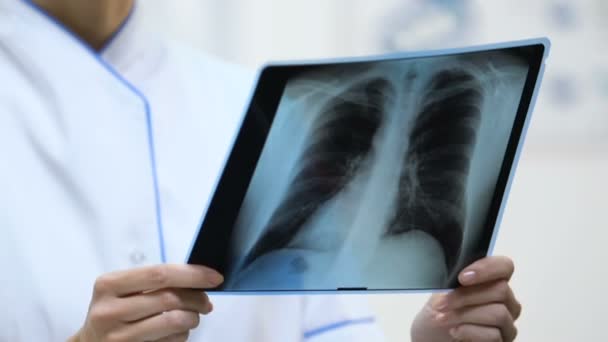 Γυναικεία θεραπεύτρια που κρατά ακτινογραφία πνεύμονα, αποτέλεσμα εξέτασης ασθενούς, διάγνωση — Αρχείο Βίντεο