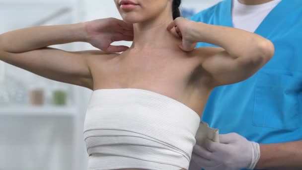 男医生在女性患者胸部包裹弹性合乳房，骨外伤 — 图库视频影像