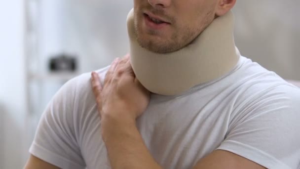 Man wearing foam cervical collar suffering from pain in shoulder and neck — Stock Video