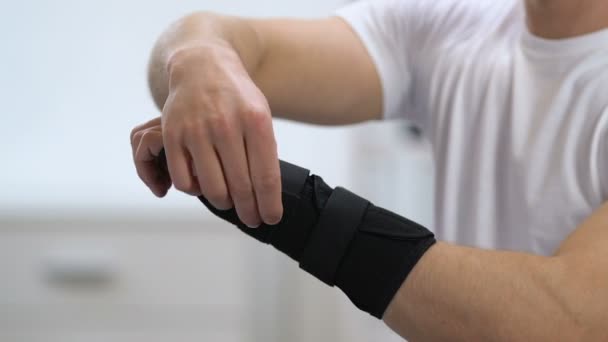 Man wearing titan wrist support, joint health problems, inflammation, close-up — Stock Video