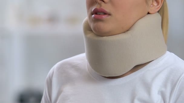 Woman in foam cervical collar feeling neck pain after trauma, rehabilitation — Stock Video