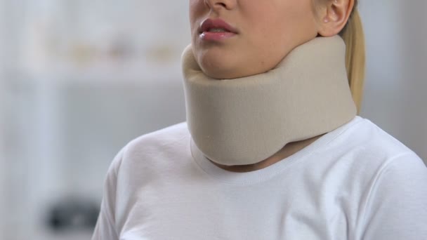 Lady in foam cervical collar suffering from strong neck pain, rehabilitation — Stock Video