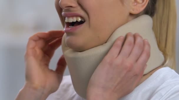 Woman in foam cervical collar turning head, feeling sharp neck pain, trauma — Stock Video