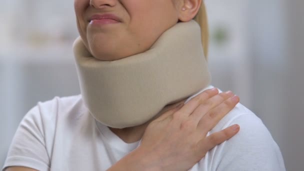 Женщина в пенопласте шейный воротник страдает от сильной боли в плече, травмы — стоковое видео