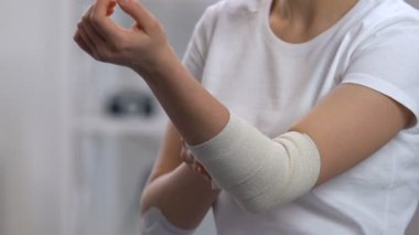 Ağrılı dirsek üzerinde elastik şal giyen kadın, artrit sorunları, hastalık