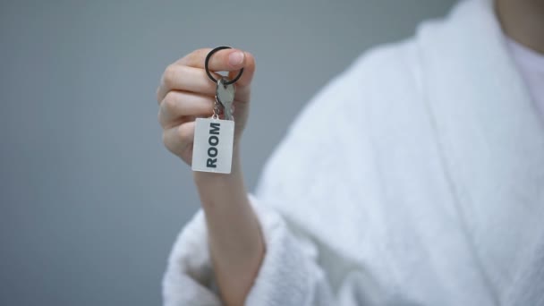 Pessoa em roupão segurando chaves com palavra quarto, sanatório resort de saúde, spa — Vídeo de Stock