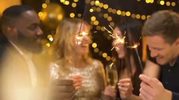 Jóvenes alegres celebrando el año nuevo, sosteniendo luces de bengala, divirtiéndose — Vídeos de Stock