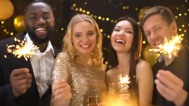 Carefree friends enjoying new year celebration in night club, holding sparklers — Stock Video