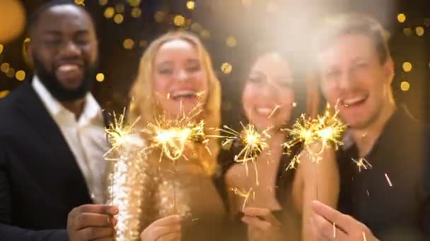 Cheerful friends showing sparklers shaped 2020, having fun in night club, event — Stock Video