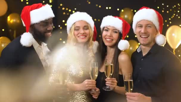 Uśmiechnięci koledzy w Santa kapelusze szczęk kieliszki szampana, imprezy firmowe — Wideo stockowe