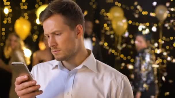 Male chatting social networks app on smartphone, feeling bored glamorous event — Stock Video