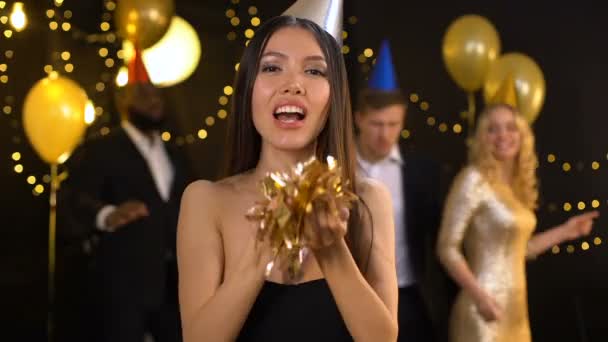 Joyful ázsiai konfetti fúj, és elküldi a levegő csók kamera, party Entertainment — Stock videók