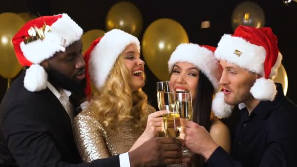 Cheerful friends in santa hats clinking glasses, New Year corporate party — Stock Video
