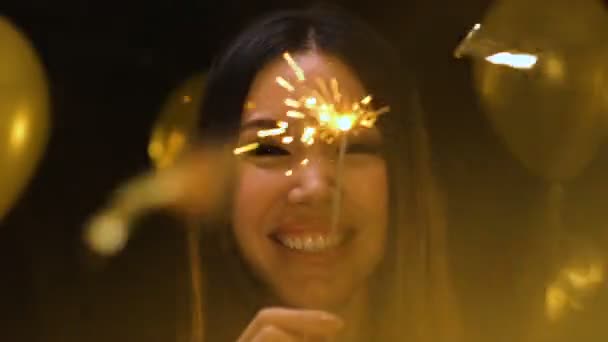 Cheerful Asian woman holding bengal light at New Year party, holiday celebration — Stock Video