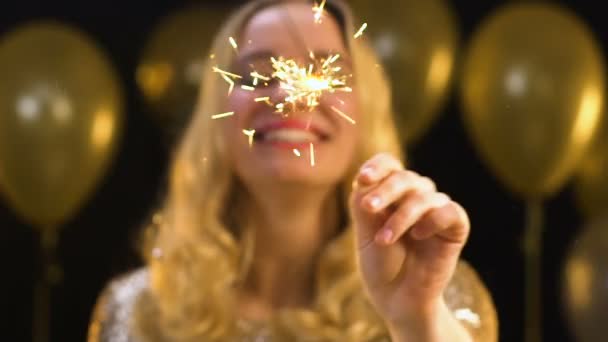 Sorridente donna caucasica con luce bengala sotto coriandoli cadenti, festa di Capodanno — Video Stock