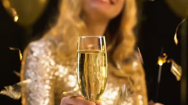 Lächelnde blonde Dame mit einem Glas Champagner und Bengallicht, Konfetti fällt