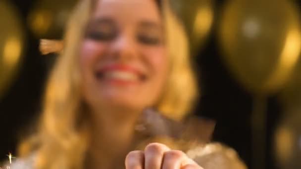 Кавказька жінка розмахуючи бенгальським світлом під падінням конфетті, свято святкування — стокове відео