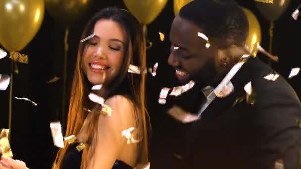 Multirasový pár flirtování a tance pod padající konfety, jednonoční stánek — Stock video