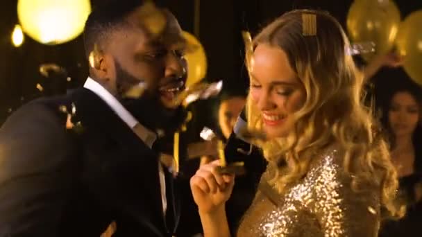 Пара смешанных рас танцует на вечеринке под падающими конфетти, развлечения — стоковое видео