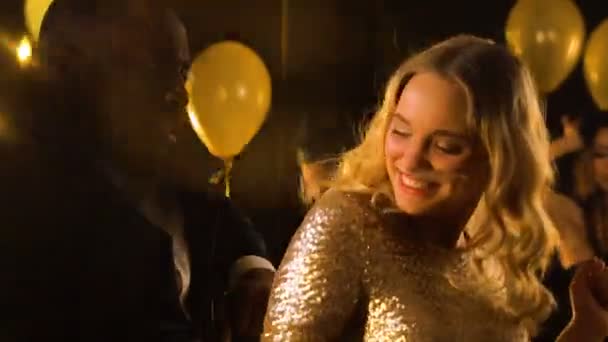 Multirracial homem e mulher dançando na festa sob queda confetti, celebração — Vídeo de Stock