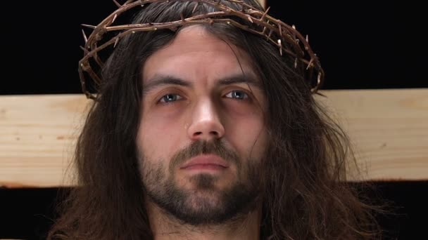 Pleurer Jésus-Christ en couronne d'épines regardant la caméra, crucifixion sur la croix — Video