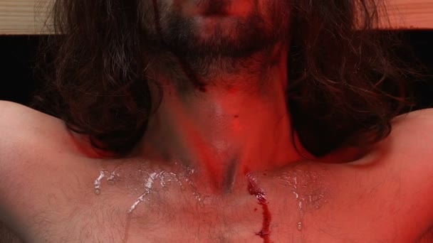 Jesus Christus mit blutendem Körper am Kreuz gekreuzigt, Blick in die Kamera, Bestrafung — Stockvideo