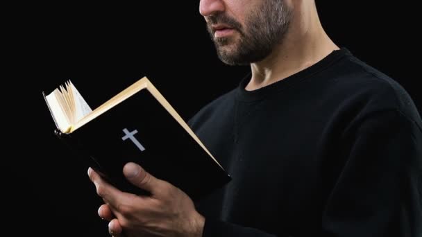 L'uomo barbuto che legge la santa Bibbia, pregando Dio sullo sfondo scuro, salmo — Video Stock