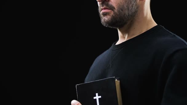 Pobre hombre sosteniendo la sagrada biblia, esperando una vida mejor, expiación de pecados, creencia — Vídeos de Stock