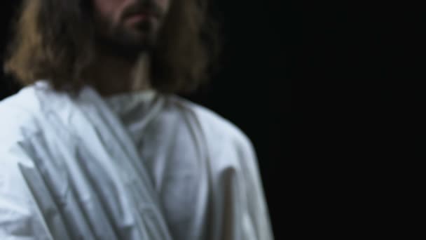 Jezus Christus het bereiken van zijn hand tegen donkere achtergrond, het helpen van mensen — Stockvideo