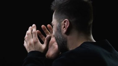 Umutsuz adam elleri ile yüz kapatıyor ve derinden karanlık arka plan karşı ağlıyor