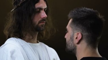 İsa genç sefil adam sarılma ve kamera bakarak, günahları affetmek