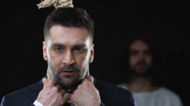 İsa boynuna hangmans ilmik ile iş adamı omuz el koyarak