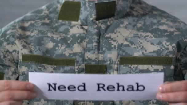 Ha bisogno di riabilitazione scritta su carta in mani di soldato maschile, aiuto a reduci di guerra — Video Stock