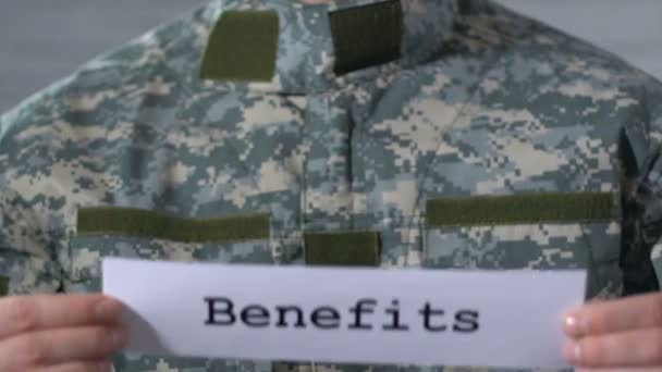 Benefícios escritos em papel em mãos de soldados, assistência financeira a veteranos — Vídeo de Stock