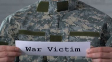 Savaş kurbanı erkek askerin elinde kağıt üzerine yazılmış, Ptsd kavramı, closeup