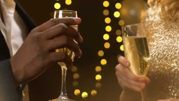 Multietniskt par spottar champagne på nyårsfest, lyser glödande, närbild — Stockvideo