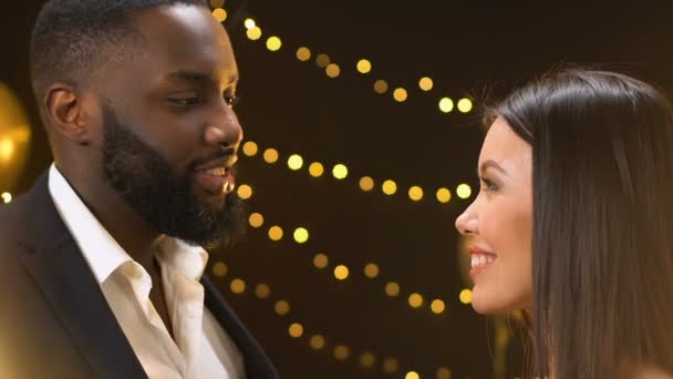 Afro-americký muž a Asijská dáma popíjí šampaňské a usmívají se, flirtuje na večírku — Stock video