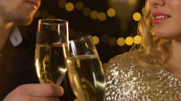 Kaukasiska par spottar champagne på fest, lyser glödande på bakgrunden — Stockvideo