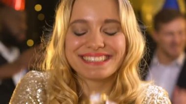 Konfeti üfleme ve doğum günü partisinde hava öpücük yapma neşeli gülümseyen bayan