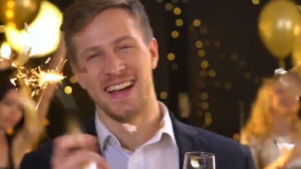Hombre guapo con luz de bengala y champán haciendo movimientos de baile en la fiesta — Vídeos de Stock