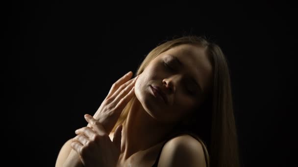 Соблазнительная молодая женщина гладит тело на черном фоне, эскорт-сервис — стоковое видео