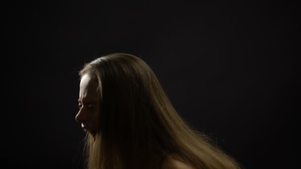 Молода жінка ледве дихає і кричить на темному тлі, проблеми — стокове відео