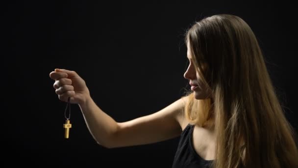 Young woman putting on necklace with cross, accepting God, religion and faith — Stock Video