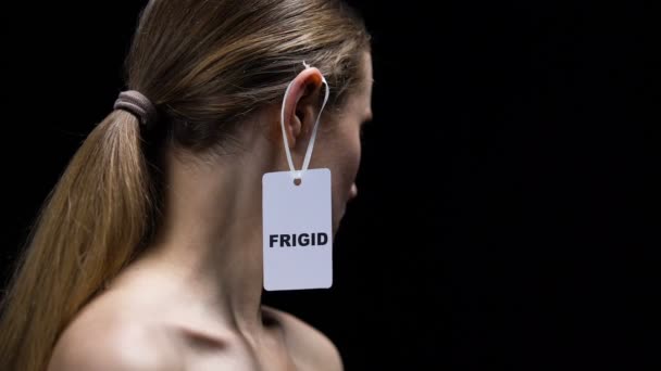 Donna che toglie etichetta frigida da orecchio, protesta contro insicurezze nel sesso — Video Stock