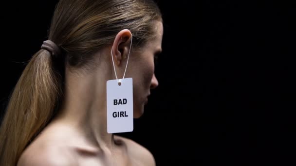 Mujer quitando la etiqueta de chica mala de la oreja, lucha contra el estereotipo y el prejuicio — Vídeos de Stock