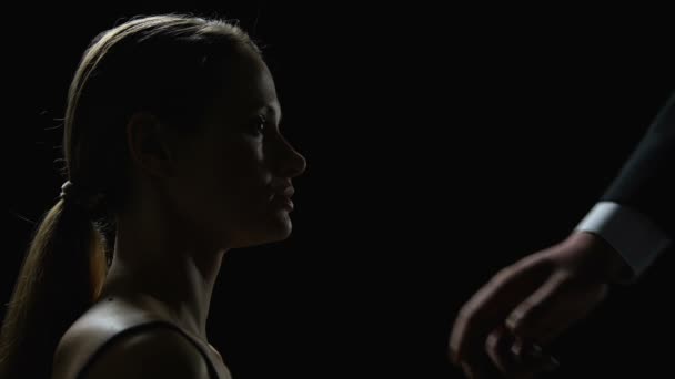 Erkek el karanlık arka plan, insan kaçakçılığı karşı genç kadın yüzü dokunmadan — Stok video