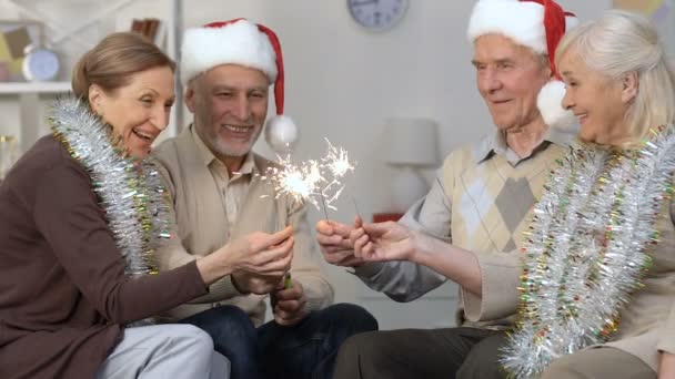 Pessoas aposentadas felizes segurando faíscas celebrando o Ano Novo juntos, férias — Vídeo de Stock