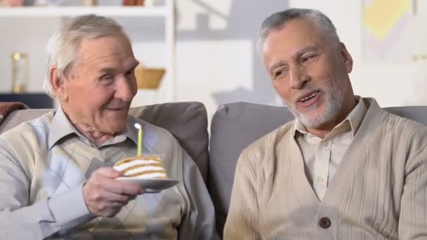 Hombre mayor presentando pastel de cumpleaños con vela, conexión de amistad, sorpresa — Vídeos de Stock