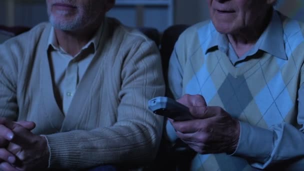 Amici di sesso maschile in pensione guardando film in casa di cura, pensione tempo libero, relax — Video Stock