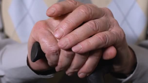 Мужские руки в возрасте на трости крупным планом, социальные пенсионные реформы, здравоохранение — стоковое видео